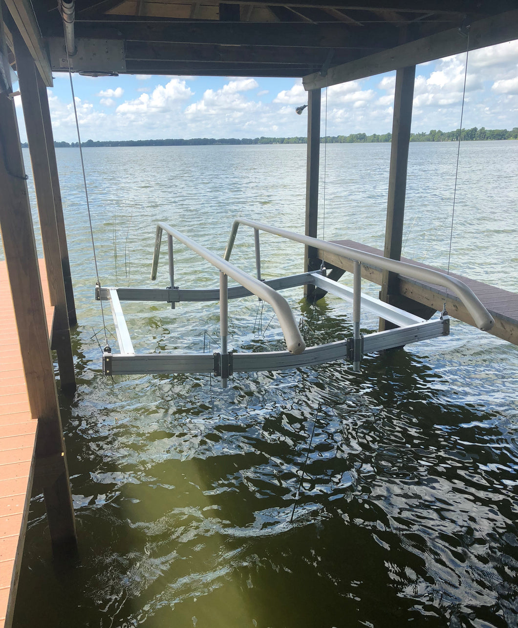 Pontoon or tritoon boat lift rail cradle kit in a boathouse